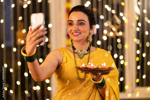 Photography Happy woman taking selfie over phone at home during Diwali