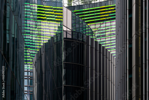 A modern cityscape featuring tall glass buildings reflecting each other in an intricate pattern of lines and colors, showcasing urban architecture and design.