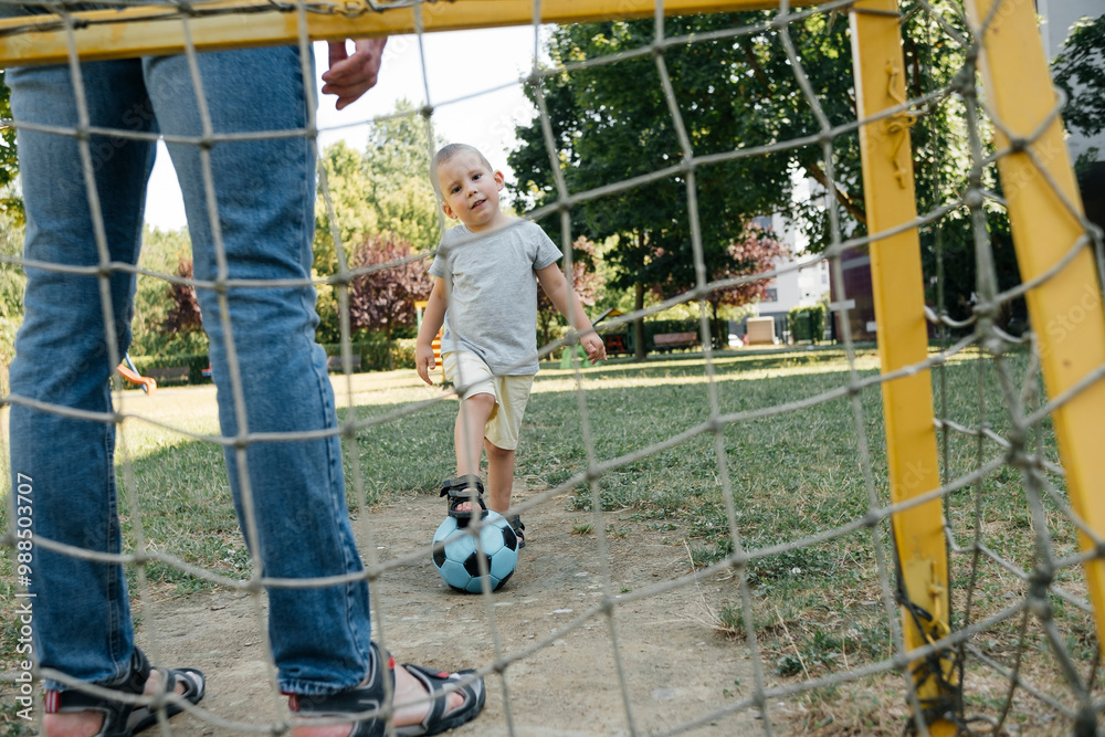 Boy with one leg on soccer ball standing in playground