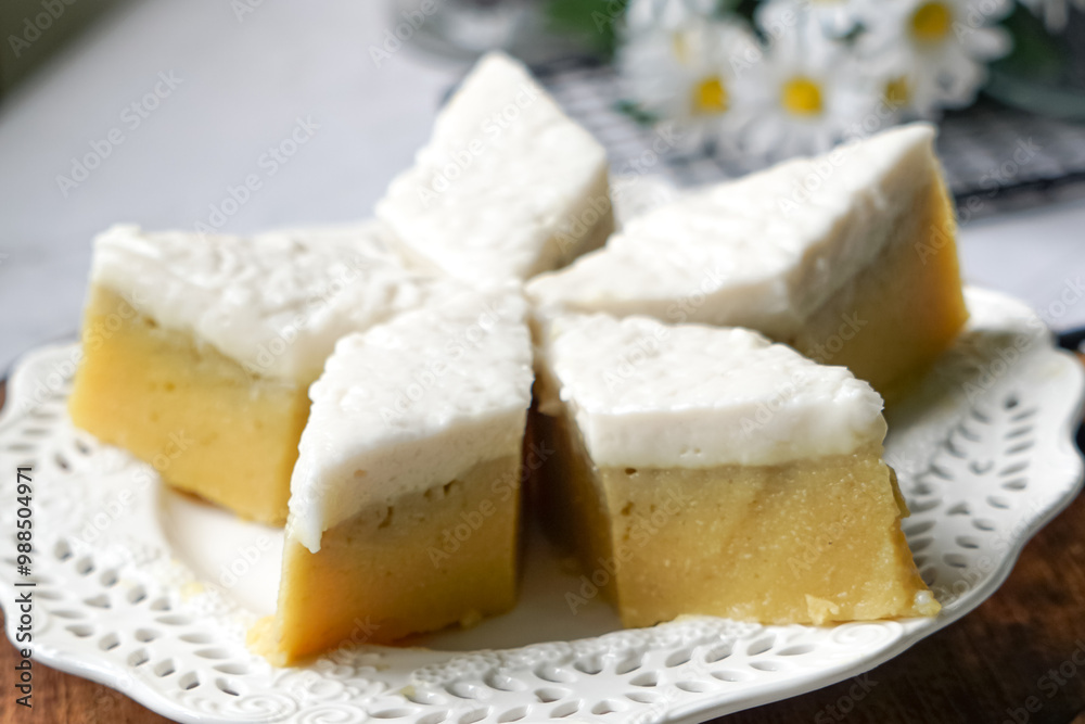 Kuih Talam Pisang, a steamed dessert made with banana and rice flour, featuring a soft, layered texture and sweet, creamy flavor. Kuih Talam Pisang, a steamed dessert made with banana and rice flour, featuring a soft, layered texture and sweet, creamy flavor.