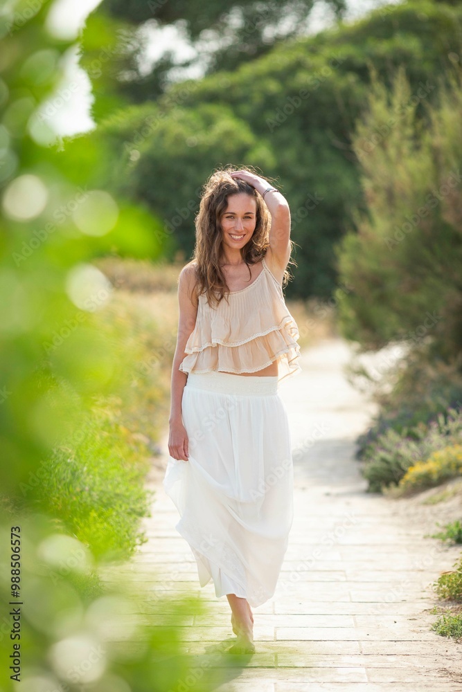 Cheerful woman with head in hand walking on footpath Cheerful woman with head in hand walking on footpath