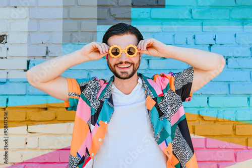 Cheerful man wearing sunglasses in front of brick wall photo