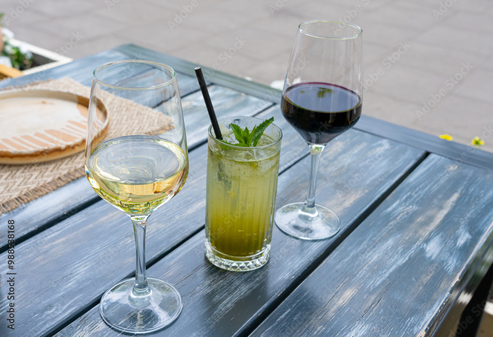 Red wine, herbal lemonade and white wine glasses on restaurant table. Family dinner in restaurant Red wine, herbal lemonade and white wine glasses on restaurant table. Family dinner in restaurant
