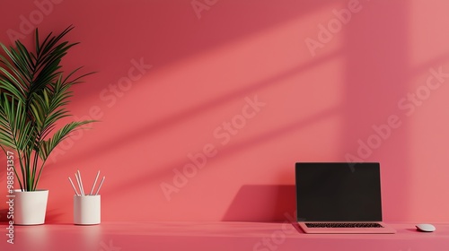 A stylish workspace featuring a pink wall, laptop, and potted plant, perfect for modern decor inspiration.