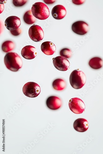 Fresh cranberries in mid-air, dynamically falling and scattered, isolated on a clean white background.