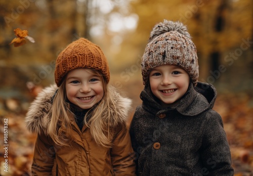 two children smiling and walking in light autumn forest, lot of fallen leaves on ground