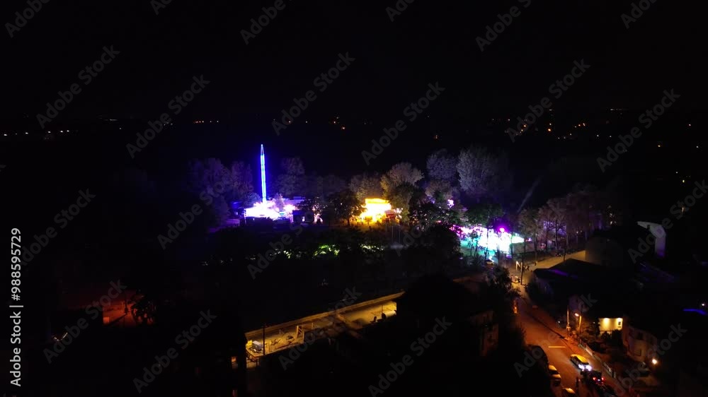 aerial drone view of festive vibrant party lights and laser on funfair festival in dark aerial drone view of festive vibrant party lights and laser on funfair festival in dark