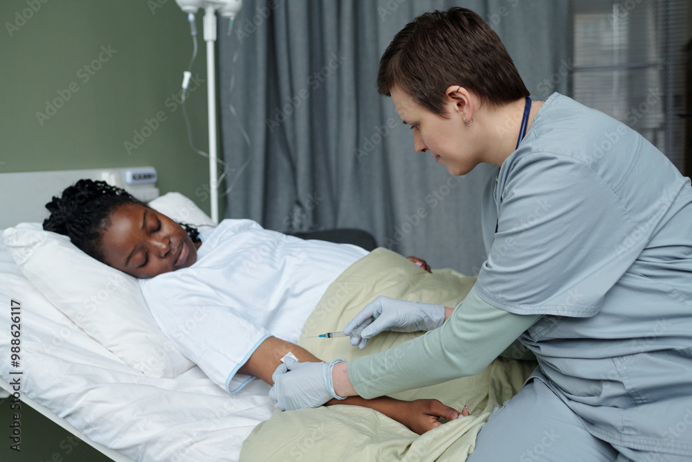 African American patient resting in hospital bed while medical professional examining and providing care. Patient appears relaxed and comfortable during the procedure African American patient resting in hospital bed while medical professional examining and providing care. Patient appears relaxed and comfortable during the procedure