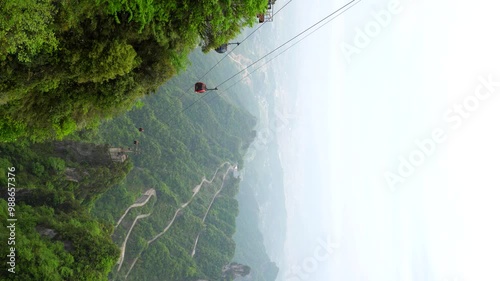 Vertical static high angle shot of Tianmen Mountain, cable car and lush vegetation in Zhangjiajie, China