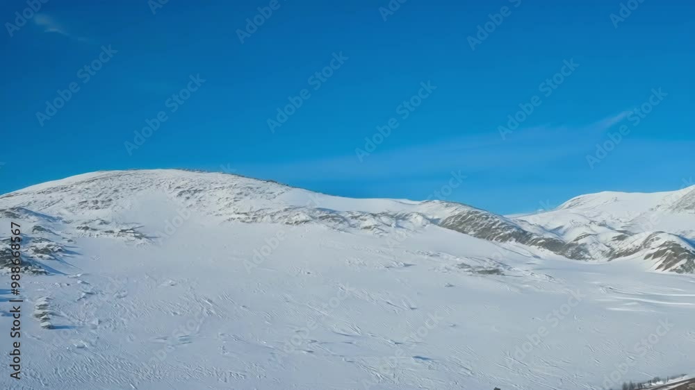 Sunlight gently illuminating stunning snow covered mountains on a winter day, under a clear blue sky, creating a serene and picturesque view Sunlight gently illuminating stunning snow covered mountains on a winter day, under a clear blue sky, creating a serene and picturesque view