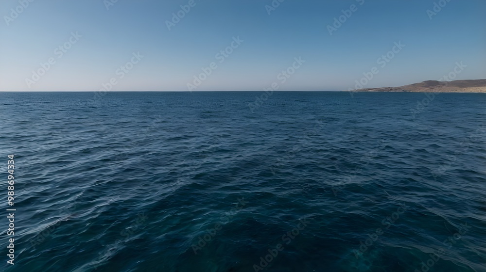 Fototapeta premium Blue ocean water under a clear blue sky, showcasing crystal-clear water on a warm summer day with tranquil waves