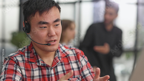 Young asian businessman working on laptop computer wearing headphone at home