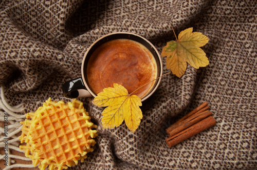 Cozy autumn coffee with leaves and a blanket
