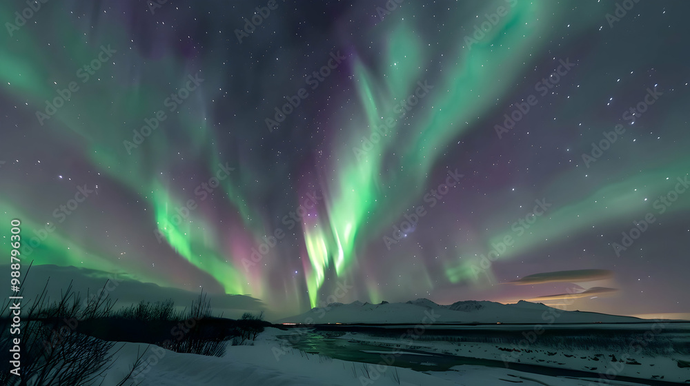 Naklejka premium Stunning Aurora Borealis Display Over Frozen River and Mountains