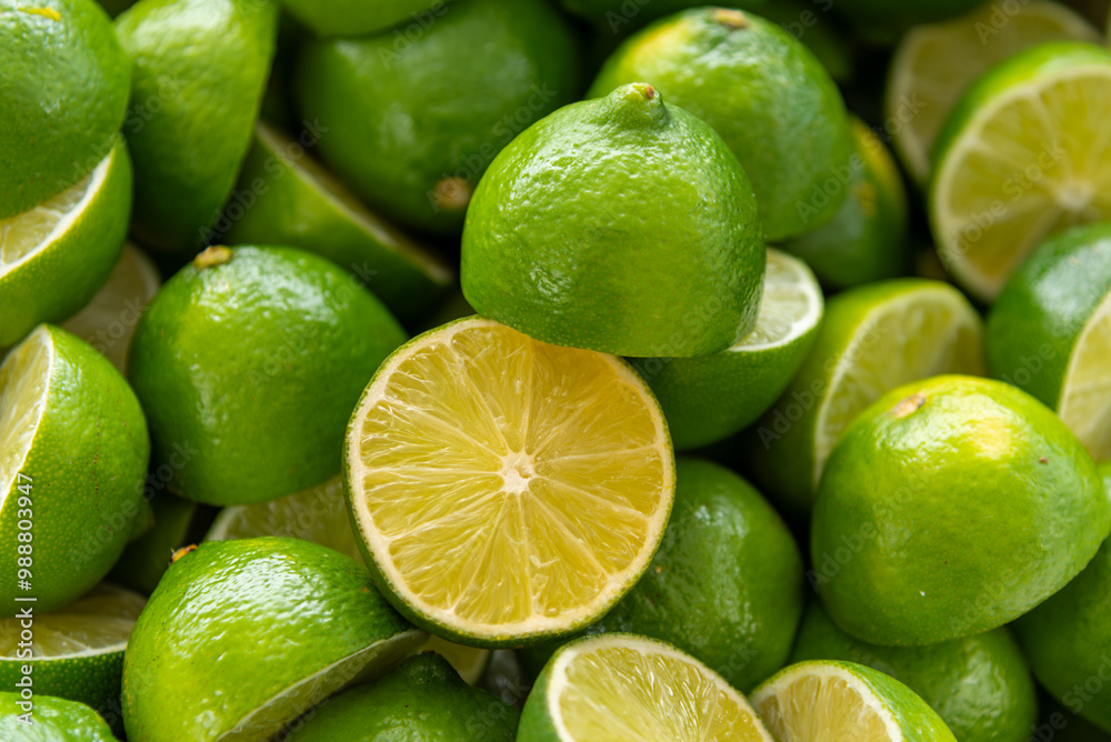 Lime cut on blurred background of several limes greens in top view Lime cut on blurred background of several limes greens in top view