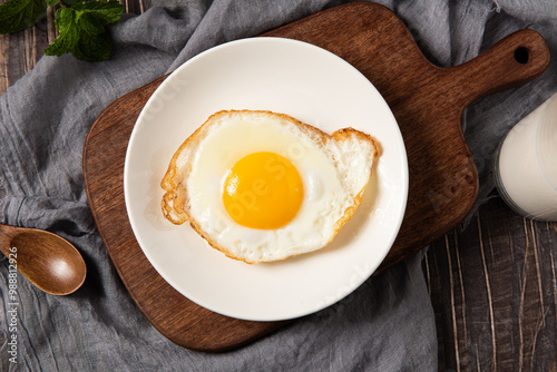 fried egg in a white plate on table. photo