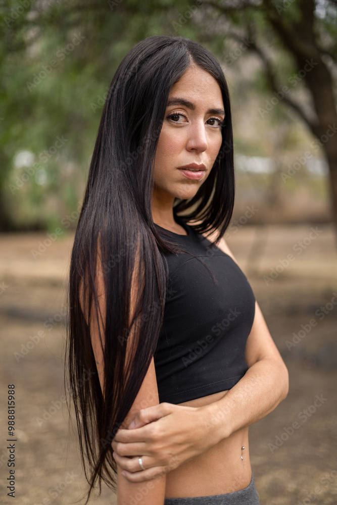 Fototapeta premium Portrait of beautiful young woman with straight hair and natural beauty, wearing sportswear on a sunny day, latin person, model
