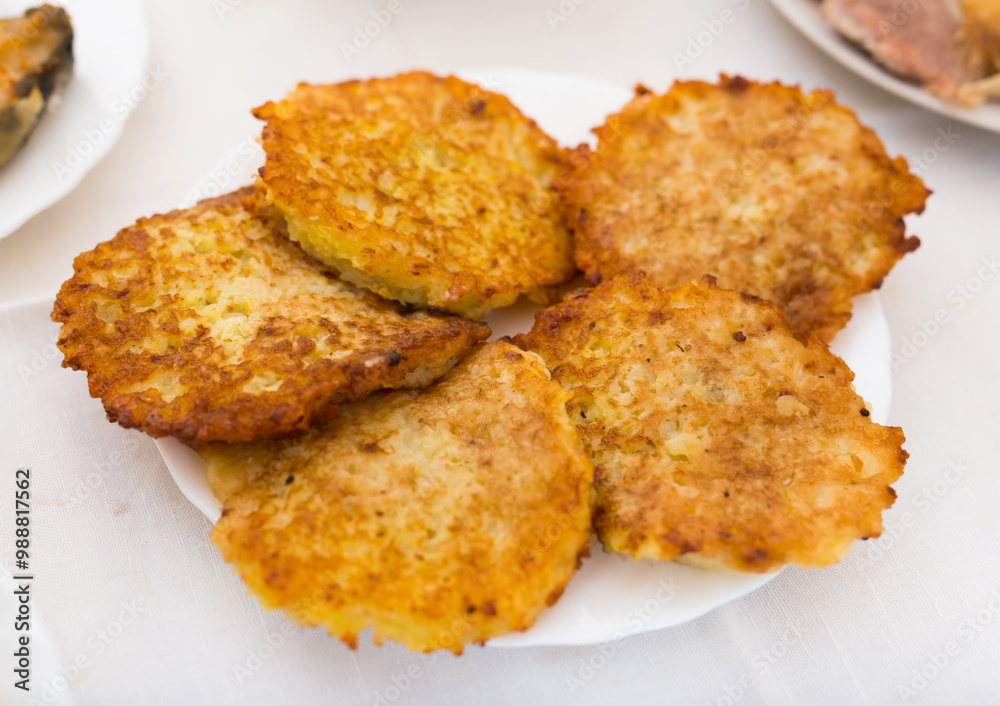 Fried grated potato pancakes with sour cream on white plate Fried grated potato pancakes with sour cream on white plate