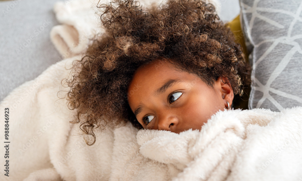 Pensive sad african american child girl lying on pillow in bed at home. Sick ill virus child concept Pensive sad african american child girl lying on pillow in bed at home. Sick ill virus child concept