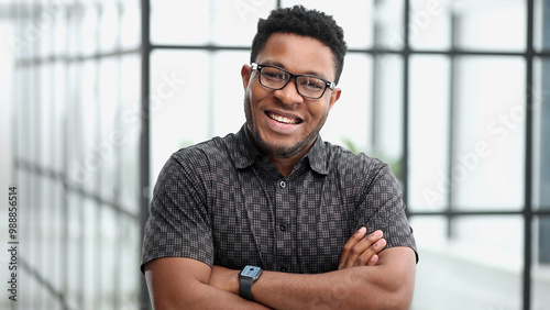 Portrait of happy African American small business owner posing with hands folded