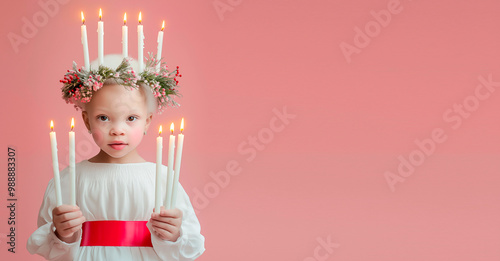 A little african albino girl dressed as Saint Lucia, with blonde hair and a green wreath on her head, in a white dress with a red belt and holding candles in her hands. Pink pastel background with. Hy photo