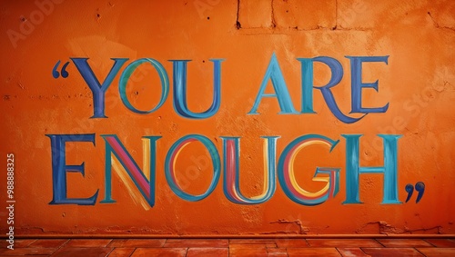 you are enough inspirational quote painted on a rustic orange wall background