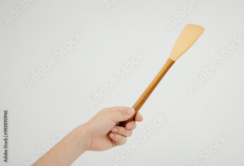 Hand holding a kitchen spatula on a white background 