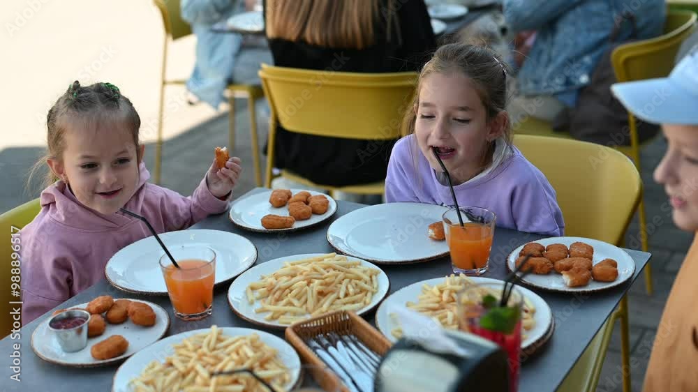 Siblings enjoy fast food and juice together in an outdoor cafe. They are laughing, talking, and having a good time. Siblings enjoy fast food and juice together in an outdoor cafe. They are laughing, talking, and having a good time.