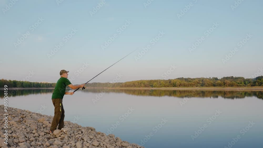 Active senior men casting fishing rod along the river coast. Enjoying retirement in beautiful nature scenery at sunset. Active senior men casting fishing rod along the river coast. Enjoying retirement in beautiful nature scenery at sunset.