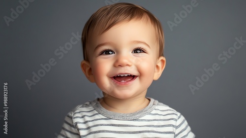 Close-up portrait of a happy baby boy in a striped shirt.