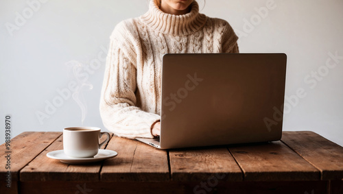 집에서 커피를 마시면서 노트북을 하는 니트를 입은 여성