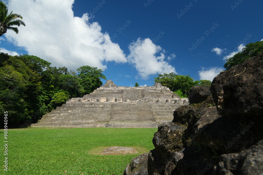 Exploring the ancient Mayan ruins of Caracol in Belize under a bright blue sky surrounded by lush greenery Exploring the ancient Mayan ruins of Caracol in Belize under a bright blue sky surrounded by lush greenery