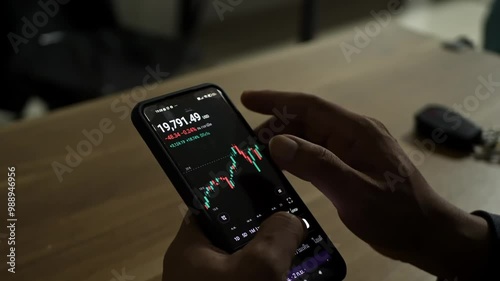 Man looking at stock charts on mobile phone and tablet screen