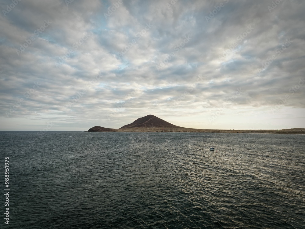 Serene ocean with distant island and cloudy sky. Serene ocean with distant island and cloudy sky.
