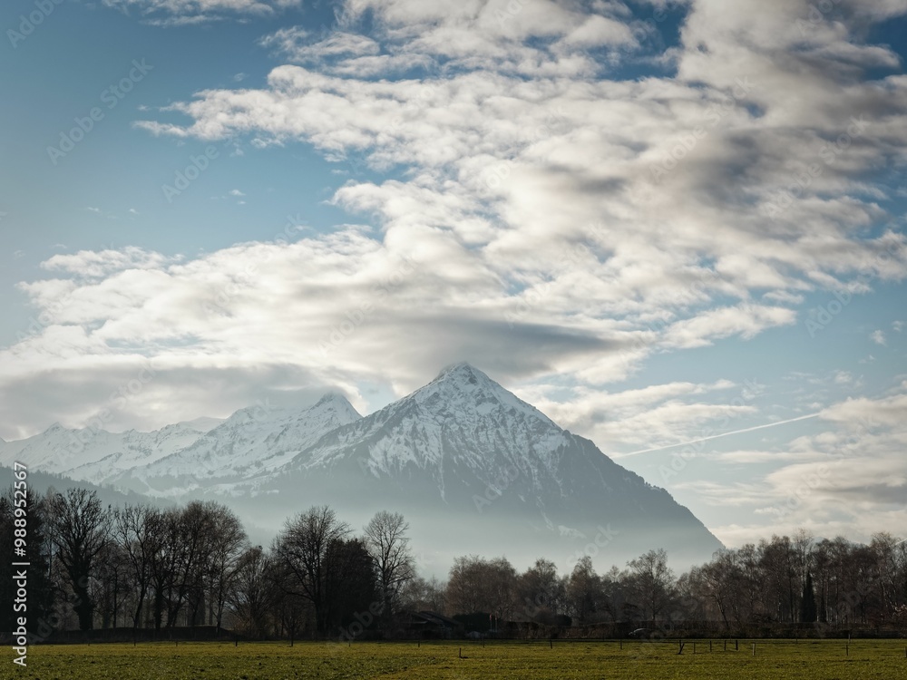 Snow-capped mountain landscape under partly cloudy sky Snow-capped mountain landscape under partly cloudy sky