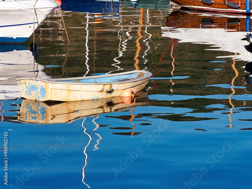 Canvas Print Colourful small boats reflected in calm harbour waters on a September morning