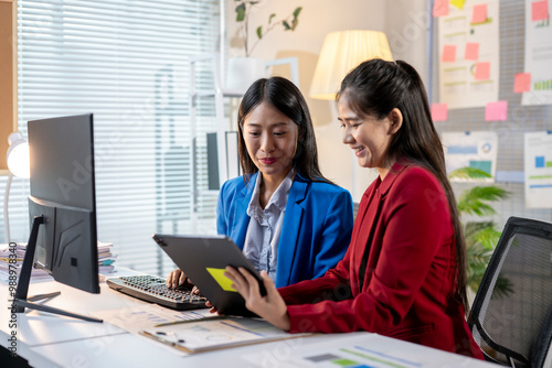 Two women are sitting at a desk