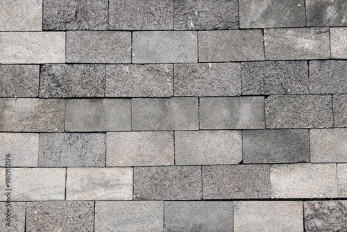 A close-up image of a grey brick wall with a textured surface, perfect for backgrounds or design elements.