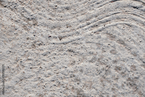 This high-resolution image captures the intricate details of weathered concrete, featuring a unique pattern of curved lines and subtle cracks. Ideal for design projects, website backgrounds, or creati