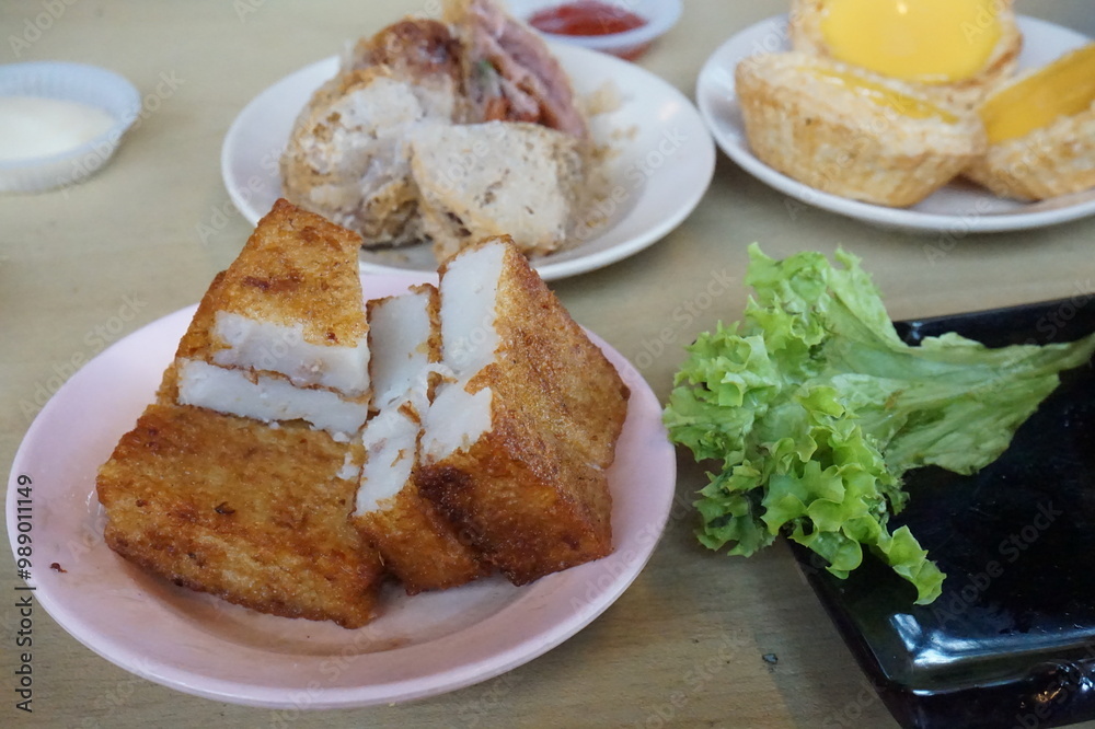 Traditional Chinese dim sum in metal bowl on wooden table. A lot of different kinds of food and drinks on the table Traditional Chinese dim sum in metal bowl on wooden table. A lot of different kinds of food and drinks on the table