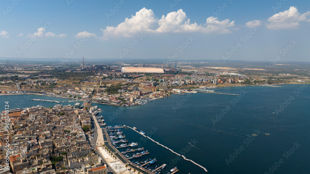 Naklejka premium Aerial view of the Tamburi district in the outskirts of Taranto, Puglia, Italy. In background is the ILVA plant.
