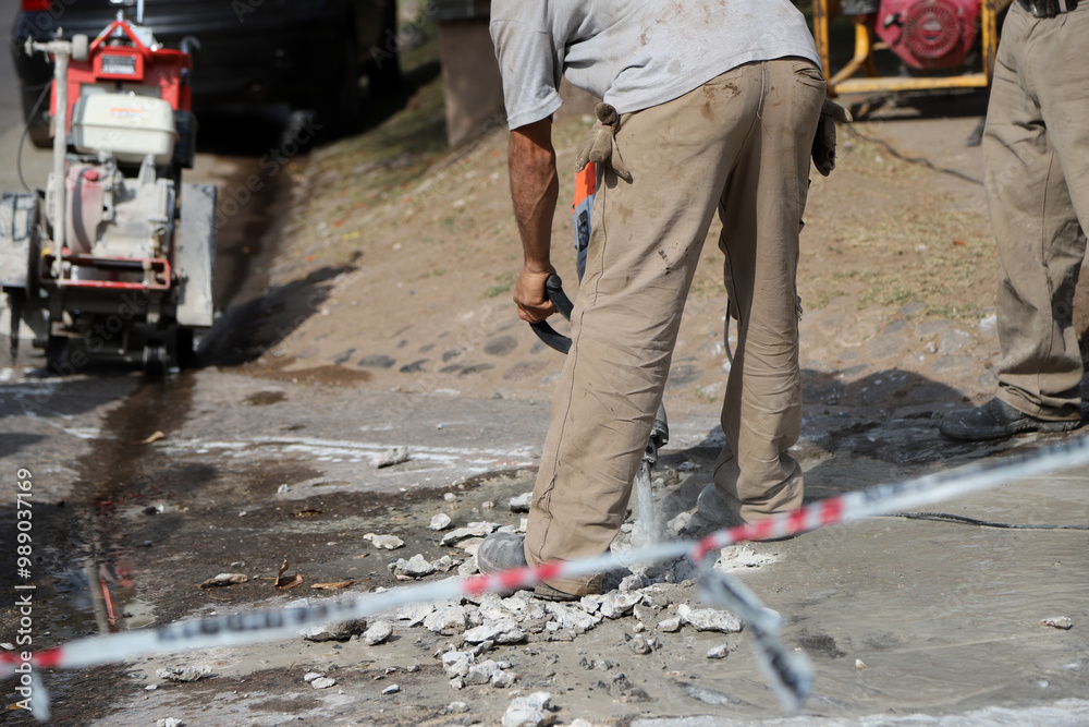 Road workers repairing a street. Men working with a pneumatic hammer breaking the asphalt of a street. Road industry.
Road workers repairing a street. Men working with a pneumatic hammer breaking the asphalt of a street. Road industry.