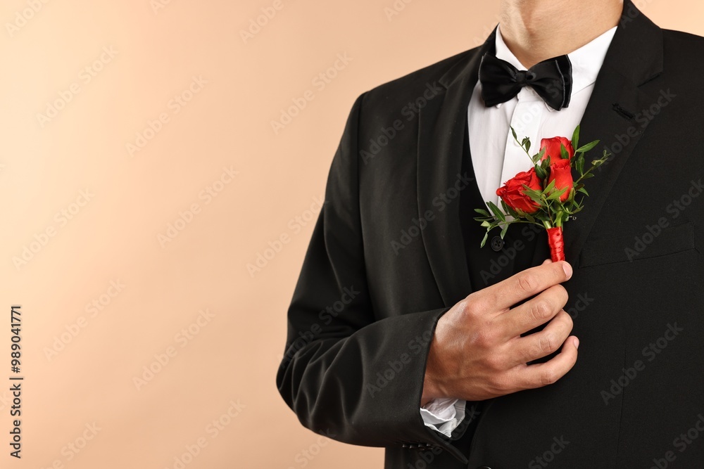 Groom in suit with stylish boutonniere on beige background, closeup. Space for text Groom in suit with stylish boutonniere on beige background, closeup. Space for text