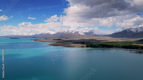 aerial view of lake tekapo new zealand, with clear sky and clouds, the lake water is bright blue photo