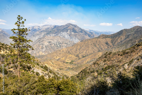 A stunning view of rugged mountains and valleys in King's Canyon National Park, California, captured during a scenic drive. The arid landscape and vast wilderness create a breathtaking scene. photo