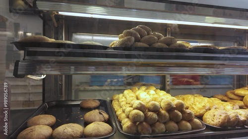 A variety of pastries and biscuits arranged on a tray are available for sale at the bakery shop.