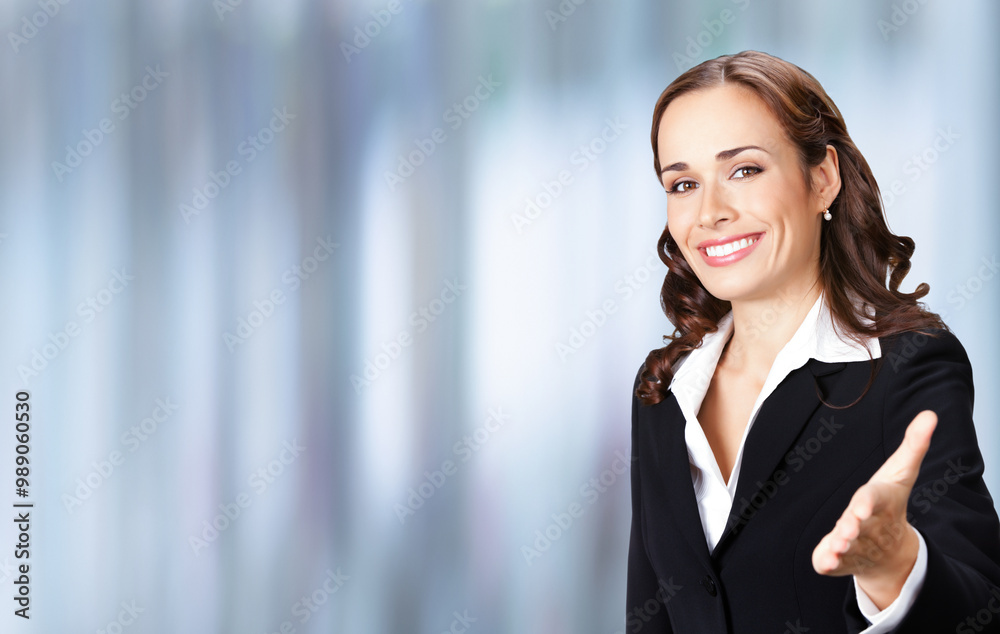 Businesswoman business woman wear confident black suit giving hand for handshake, against blurred office background. Business studio ad concept. Copy space for ad text place. Businesswoman business woman wear confident black suit giving hand for handshake, against blurred office background. Business studio ad concept. Copy space for ad text place.