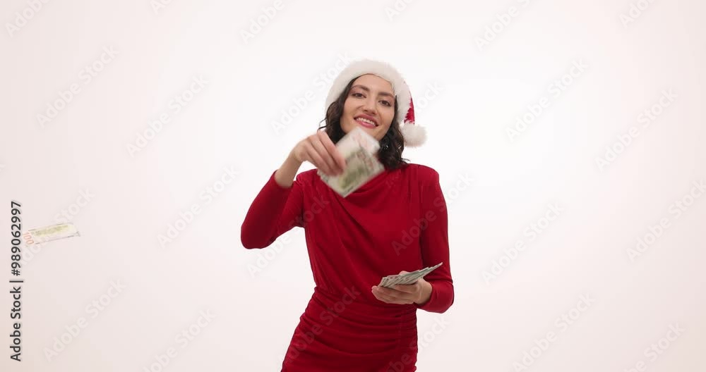 Pretty woman in Santa hat throws money in air celebrating Christmas on white background. Brunette lady wishes financial security and abundance Pretty woman in Santa hat throws money in air celebrating Christmas on white background. Brunette lady wishes financial security and abundance
