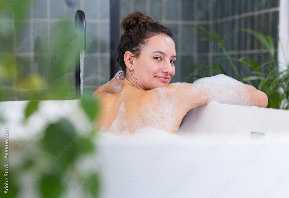 Relaxing in bathtub with bubbles, woman enjoying spa day at home