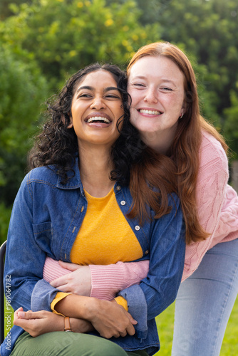 Smiling women friends hugging and enjoying time together outdoors, showing friendship photo